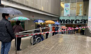 Votants fent cua per votar al mercat de la Sagrada Família.