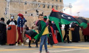 Un niño sostiene una bandera de Libia un día antes de las conmemoraciones del décimo aniversario del levantamiento contra el exlíder Muammar Gaddafi, en Trípoli, Libia, el 16 de febrero de 2021.