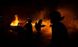 Els Bombers apaguen un foc generat en el transcurs dels aldarulls després de la manfestació per l'empresonament del raper Pablo Hasel a Barcelona.