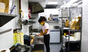 Una socia de una "cocina fantasma" prepara una comida en su lugar de trabajo.