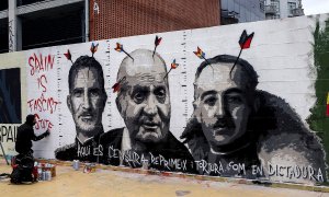 El artista grafitero Roc Blackblock diseña un mural con dibujos alusivos al dictador Francisco Franco, al rey Felipe VI y al rey emérito Juan Carlos I en un muro de los Jardines de les Tres Xemeneies de Barcelona en solidaridad con Pablo Hasel y contra la