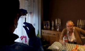 Una enfermera administra la primera dosis de la vacuna BioNTech Pfizer a un paciente mayor de 80 años en su domicilio del barrio del Raval de Barcelona.