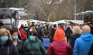 Varias personas compran en el mercadillo de Alcalá de Henares después de que la Comunidad de Madrid levantase este lunes las restricciones de movilidad por el coronavirus.