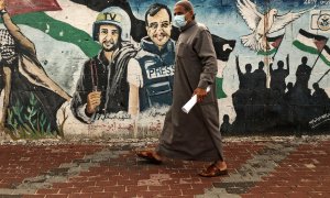 Un palestino pasa frente a un mural de periodistas asesinados en 2014 entre Hamas e Israel en Gaza.