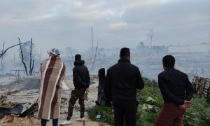 Temporeros en un asentamiento incendiado.