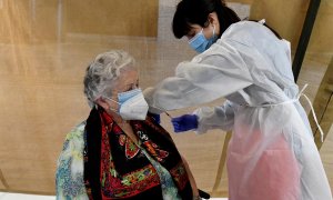 Una empleada sanitaria inocula una dosis de la vacuna contra la covid-19.