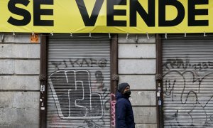 Un joven pasa por delante de un local cerrado, en venta, en el centro de Madrid. REUTERS/Susana Vera