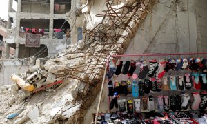 9/03/2021. Un puesto de venta de ropa cerca de los edificios dañados en Douma, al este de Damasco. - Reuters