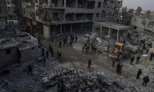 Foto de archivo (09/01/2018) de civiles y voluntarios de la Defensa Civil Siria mientras buscan sobrevivientes después de que varios ataques aéreos destruyeran edificios en la ciudad de Hamoria, al-Ghouta (Siria).
