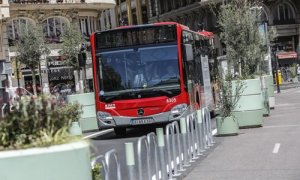 Un autobús de la línea C1 pasa al lado de los maceteros colocados en la Plaza del Ayuntamiento de Valencia.