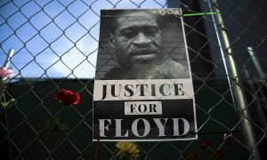 Imagen de archivo de un cartel conuna fotografía de George Floyd acompañada de mensajes de protesta y flores, en Mineápolis. - EFE