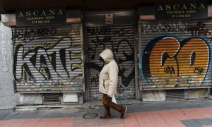 Una persona pasa por delante de un comercio cerrado, en Madrid. REUTERS/Susana Vera