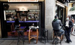 Dos personas toman un aperitivo en el exterior de un bar del Casco Viejo de Pamplona.