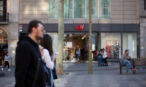 Varias personas pasan frente a una tienda de H&M en Barcelona. E.P./David Zorrakino
