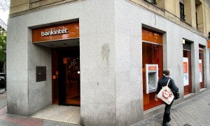 Una mujer camina junto a una oficina del Bankinter en Madrid. E.P./Eduardo Parra