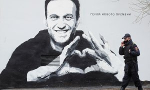 Un policía pasa frente a un mural de Navalni en San Petersburgo, Rusia