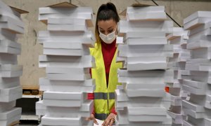 Una operaria organiza parte del material destinado a las elecciones autonómicas del 4 de mayo almacenado este martes en un centro logístico de Alcalá de Henares.