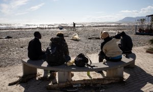 Un grupo de migrantes se sienta junto a la orilla en Ventimiglia el 3 de octubre de 2020.