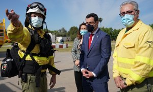 El presidente de la Junta, en el helipuerto de la Cartuja, en Sevilla, con personal del Infoca.