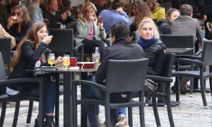 Uns joves en una taula a la terrassa d'un bar de la Plaça Independència de Girona, aquest diumenge 2 de maig de 2021.