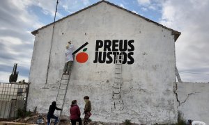 Activistes fent una pintada en defensa dels llauradors en una alqueria de l'horta valenciana.