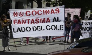 Varias personas participan en la manifestación contra la instalación de 'cocinas fantasma' en zonas residenciales y escolares del distrito madrileño de Arganzuela este sábado.