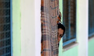 Una mujer palestina asoma desde la puerta de su casa.