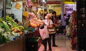 Una mujer compra fruta en un mercado de Zaragoza.