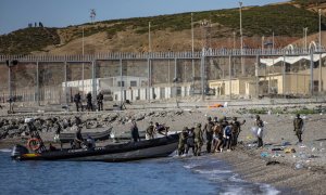 Las fuerzas armadas dirigen a un grupo de jóvenes que han cruzado a nado la frontera de Marruecos hasta llegar a la playa de Tarajal en Ceuta.