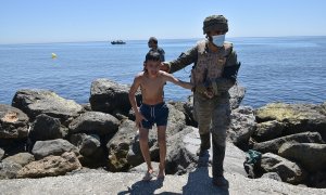 Un militar del ejército español ayuda a un menor migrante procedente de Marruecos a su llegada a Ceuta, a 19 de mayo de 2021, en Ceuta, (España).