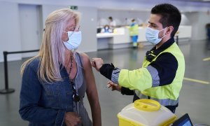 Un sanitario vacuna a una mujer con la dosis de Pfizer, en el Wanda Metropolitano, a 19 de mayo de 2021, en Madrid