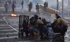 Jóvenes de la Primera Línea se enfrentan con policías del Esmad, el 18 de mayo de 2021, durante una jornada de protestas en Yumbo, Valle del Cauca (Colombia).
