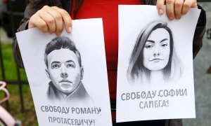 Una manifestante sujeta dos retratos de Román Protasevich y su pareja, Sofia Sapega, durante una protesta en Riga, Letonia, contra la detención de ambos.