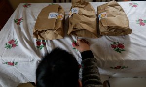 Un niño durante la comida en su casa del barrio madrileño de Carabanchel momentos antes de abrir el menú de la ONG del chef José Andrés, que reparte en Madrid a las familias más necesitadas durante el estado de alarma provocado por el coronavirus, en Madr