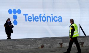 Dos guardias de seguridad, delante de una pantalla con el nuevo logo de Telefónica en su sede en la zona norte de Madrid. REUTERS/Sergio Perez