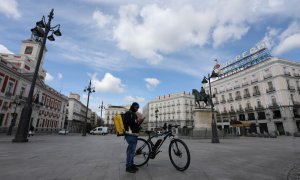 Un repartidor de la empresa Glovo mira su teléfono en la Puerta del Sol. — Marta Fernández / EUROPA PRESS