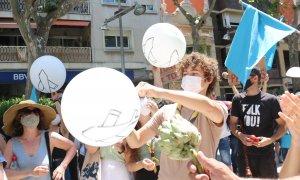 Un grup de participants en la manifestació contra l'ARE Sud i l'ampliació de l'aeroport al Prat de Llobregat petant uns globus, el 12 de juny de 2021