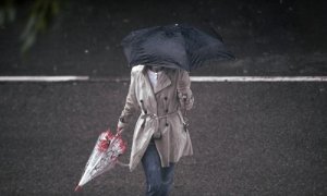 Una persona camina bajo la lluvia protegida con un paraguas, en Madrid (España) a 24 de septiembre de 2020.