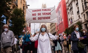 Una mujer con un cartel en la que se lee: 'Sanidad pública no se vende, se defiende', participa en la manifestación convocada por Marea Blanca, en defensa de la Atención Primaria de la Comunidad de Madrid, a 20 de junio de 2021.