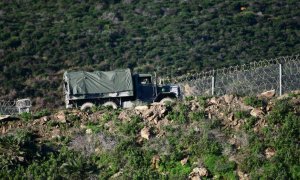 Un camión del ejército marroquí patrulla frente al tramo del vallado perimetral que separa España de Marruecos, en Ceuta.
