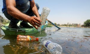 Un pescador recoge dos botellas de plástico arrojadas al río Nilo, Egipto.