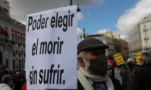Un hombre con un cartel en el que se lee: `Poder elegir el morir sin sufrir´ durante una concentración de Derecho a Morir Dignamente en la Puerta del Sol, en Madrid.