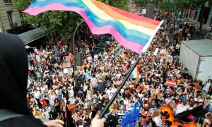 Una persona ondea una bandera del arco iris sobre una multitud de participantes de la tradicional marcha del Orgullo LGBTQ, en medio del brote de la enfermedad del coronavirus (COVID-19), en París, Francia, el 26 de junio de 2021.