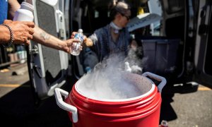 La gente usa hielo seco para enfriar agua y Gatorade debido a la escasez de hielo durante una ola de calor sin precedentes en Portland, Oregon.