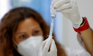 Una enfermera carga una dosis de la vacuna contra la covid que será administrada este lunes en el Corte Inglés de Arapiles, en Madrid.