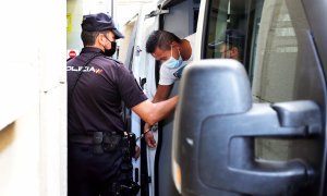 Un hombre es recibido por un agente de Policía Nacional a su llegada al juicio por el que se le acusa de participar, presuntamente, en la violación grupal de una joven de 19 años en 2019, a 5 de julio de 2021, en Alicante.
