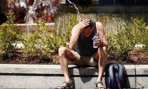 Un hombre se echa agua por la cara durante la ola de calor en Madrid.