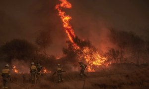 Varios bomberos forestales realizan labores de extinción en un incendio en Cualedro, Ourense, en septiembre de 2020.