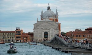 Peregrinos y turistas cruzan un puente en Venecia