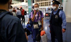 Krystsina Tsimanouskaya, escoltada por la policía del aeropuerto de Haneda, en Tokio.